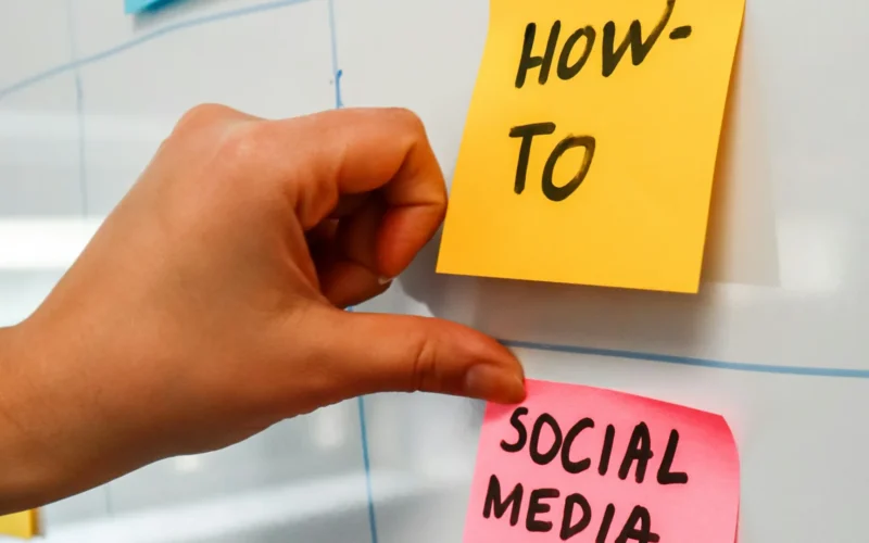 A hand pointing to sticky notes on a bulletin board