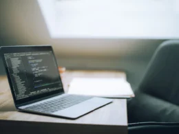 Laptop showing code in a bright office, where a team weighs Muse Wonder pricing against its current model