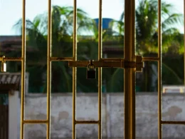 A metal gate secured with a padlock