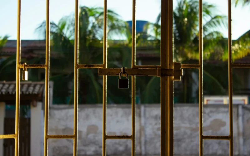 A metal gate secured with a padlock