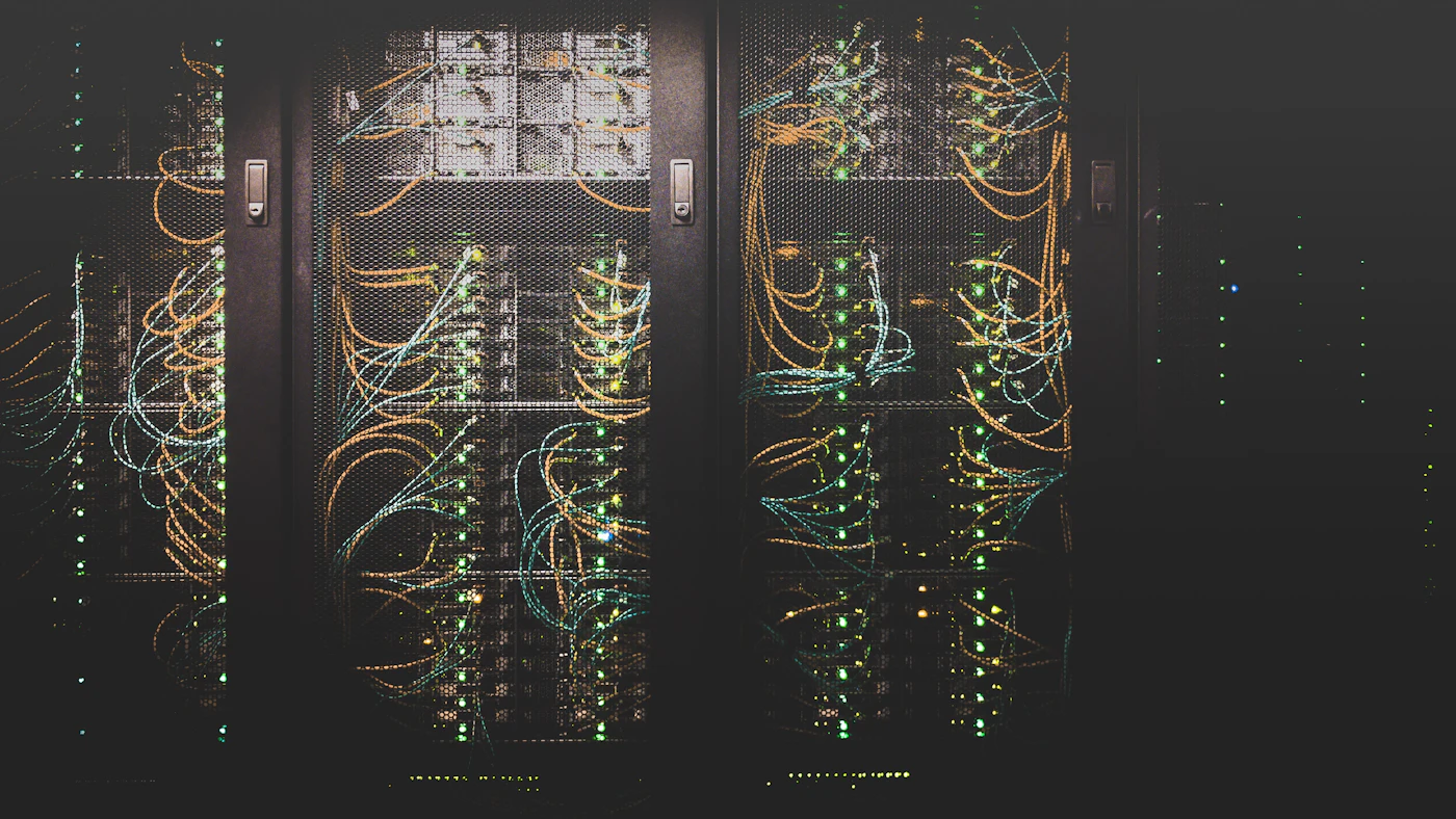 Bundles of coloured network cables running through a dark server rack