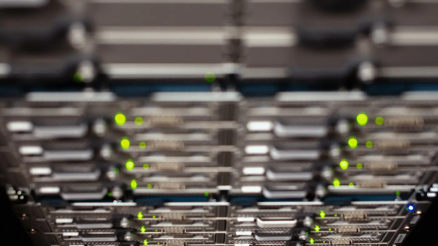 Green status lights on a rack of network switches, the kind of hardware a self-hosted AI model runs on