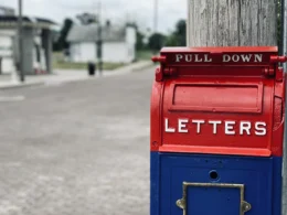 Red mail box on brown wooden post