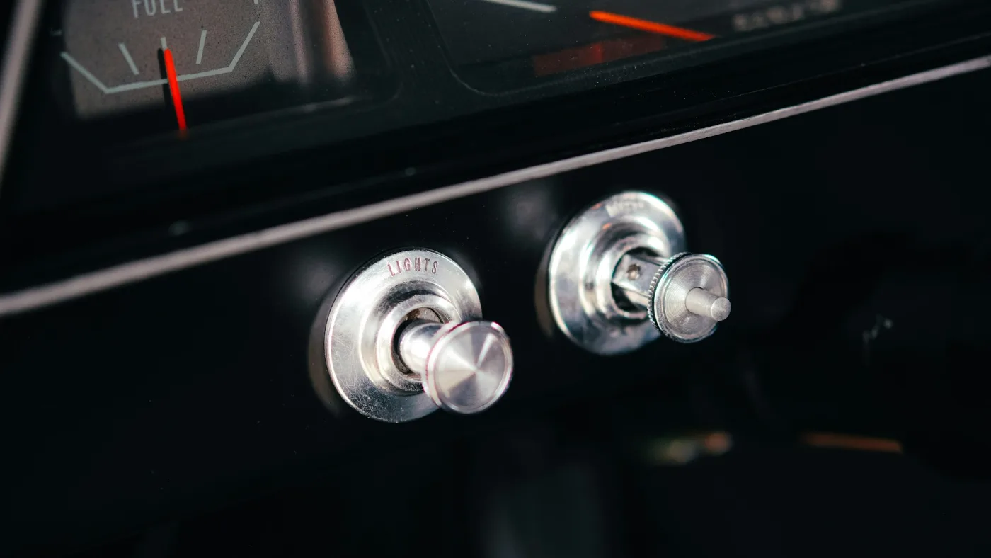 Close-up of a vintage car dashboard with a fuel gauge.