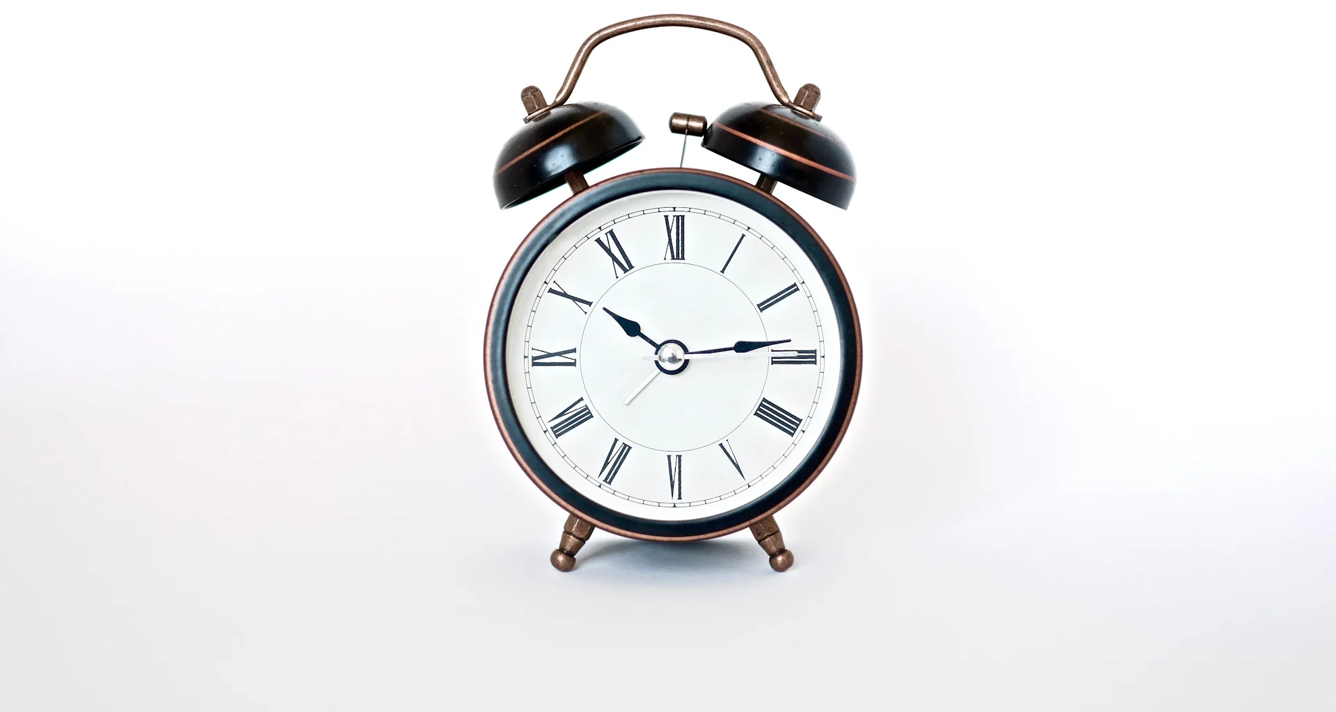 Round black and white analog alarm clock
