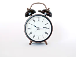 Round black and white analog alarm clock