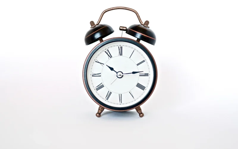 Round black and white analog alarm clock