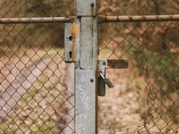 Rusted metal gate closed with a padlock