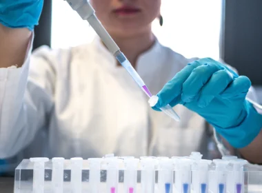 Scientist using a pipette with test tubes in a lab