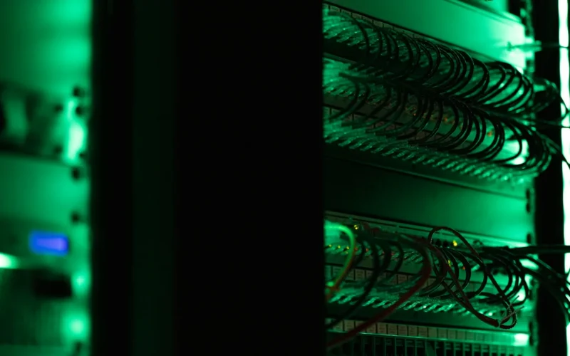 A rack of electronic server equipment in a dark room