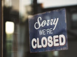 Sorry we're closed signage hanged on glass door