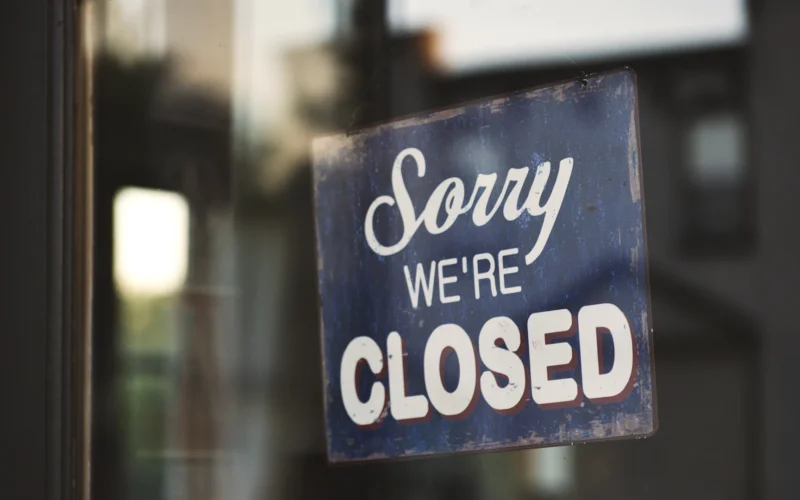 Sorry we're closed signage hanged on glass door
