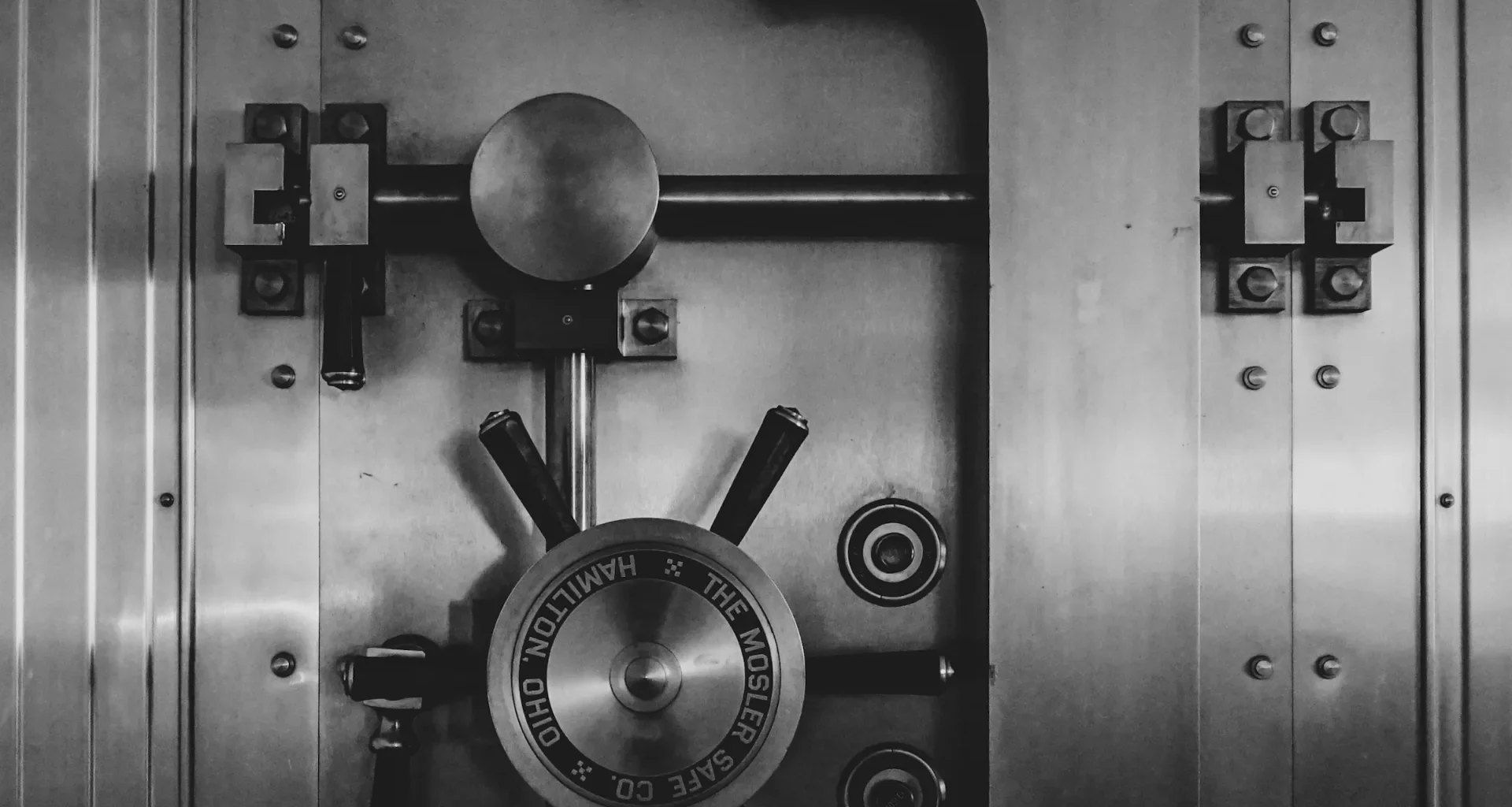 Heavy steel bank vault door with a large circular locking wheel