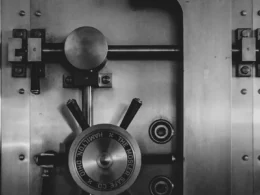 Heavy steel bank vault door with a large circular locking wheel