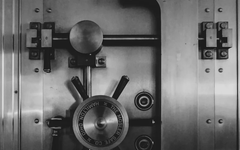 Heavy steel bank vault door with a large circular locking wheel