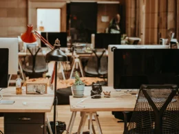 Rows of switched-off monitors on beige office desks