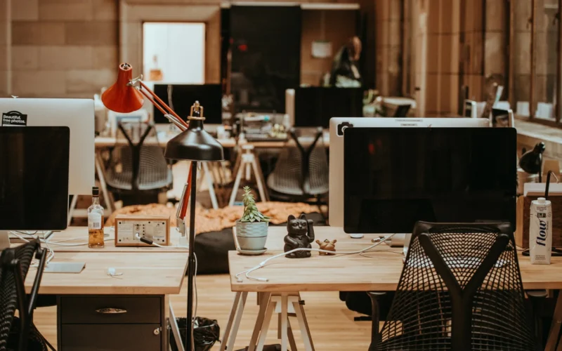 Rows of switched-off monitors on beige office desks