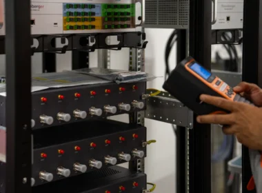 Technician inspecting server racks with a handheld device