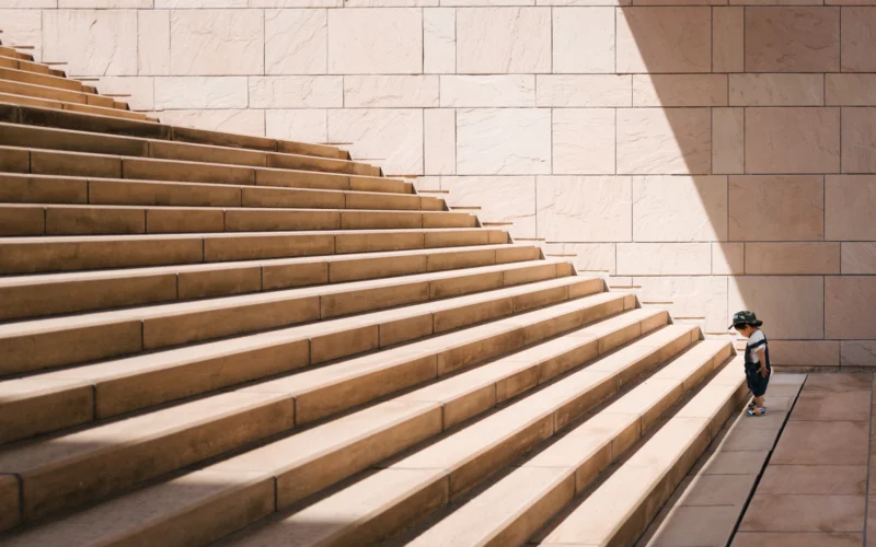 Toddler's standing in front of beige concrete stair