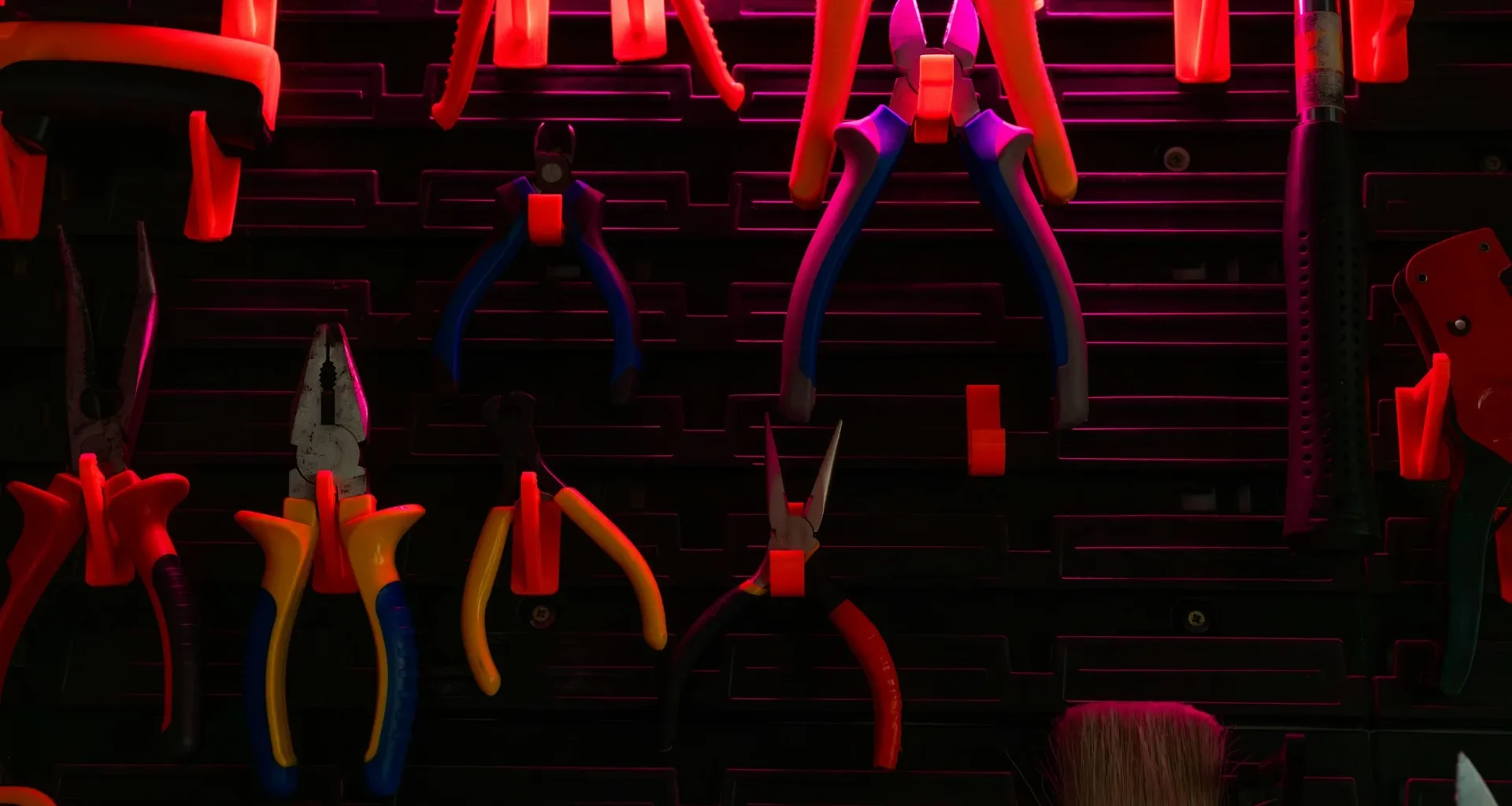 Hand tools of various kinds hanging on a workshop wall