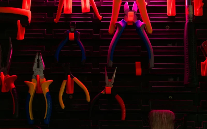 Hand tools of various kinds hanging on a workshop wall