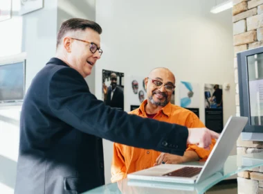 Two colleagues looking at a computer screen together