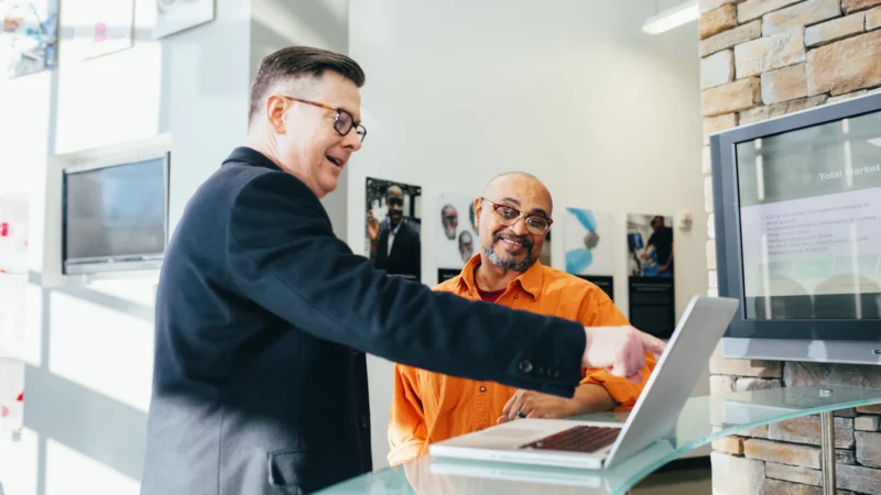 Two colleagues looking at a computer screen together