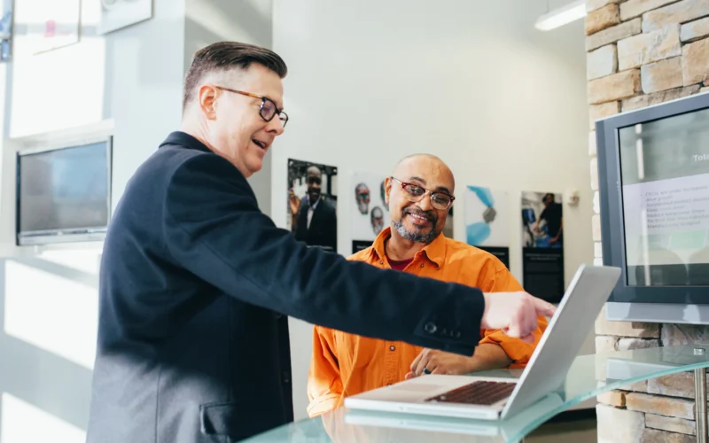 Two colleagues looking at a computer screen together