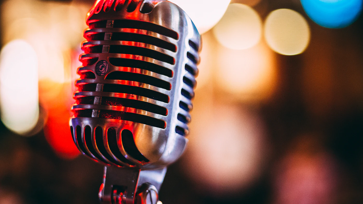 Vintage chrome microphone in front of blurred coloured lights
