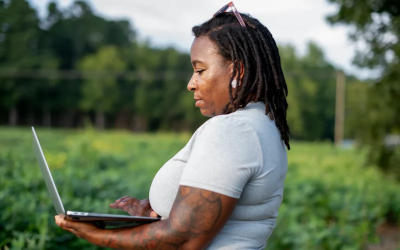 Woman using a laptop in a field