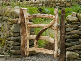 A wooden gate in front of a stone wall
