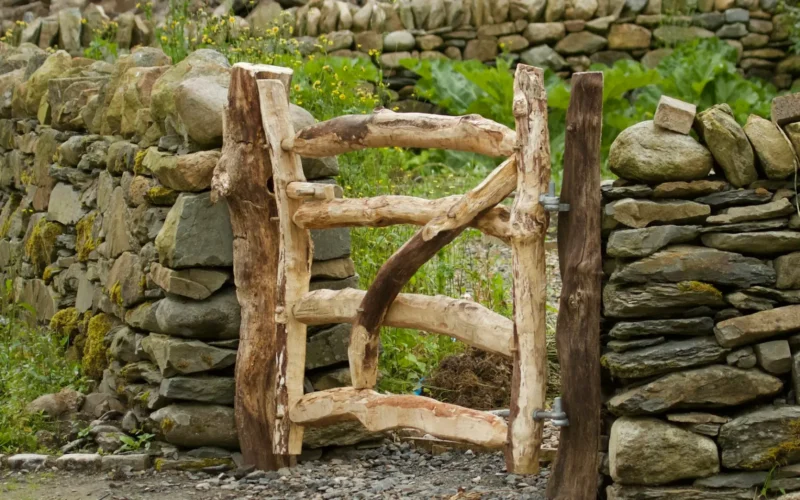 A wooden gate in front of a stone wall