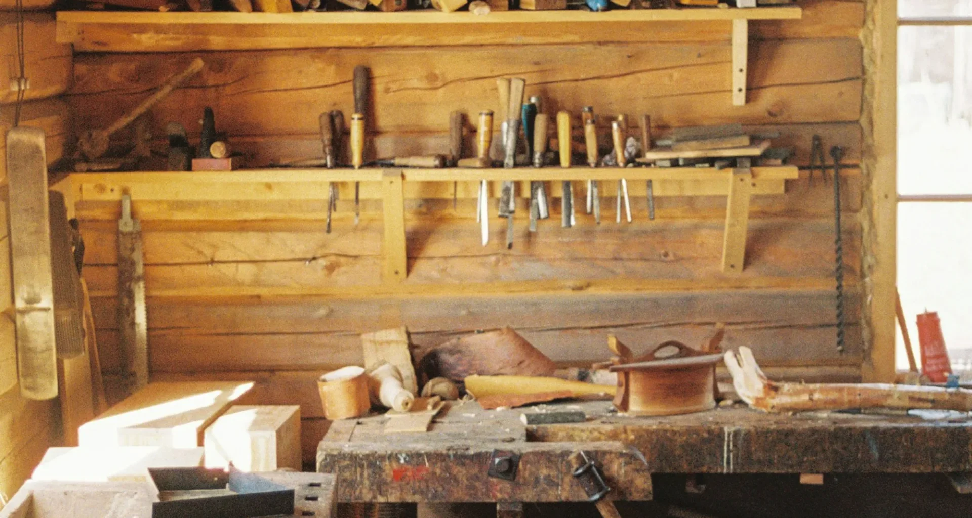A workbench in a wooden cabin with lots of tools