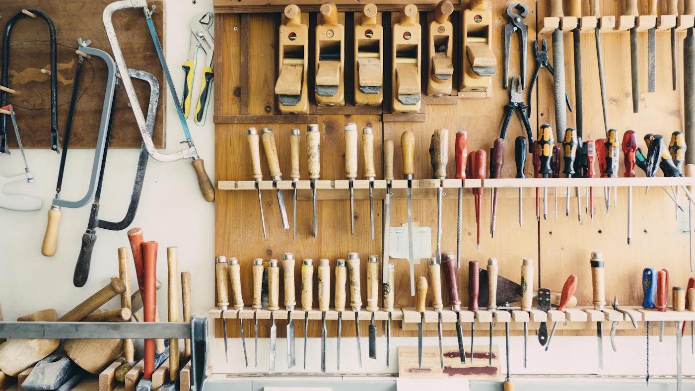Workshop wall rack holding rows of chisels, screwdrivers and hand planes